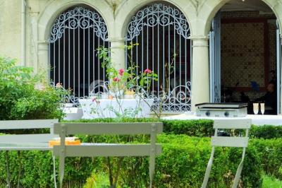 Des personnes en tenue blanche brandissent des cierges magiques lors d'un dîner en plein air devant un bâtiment éclairé.