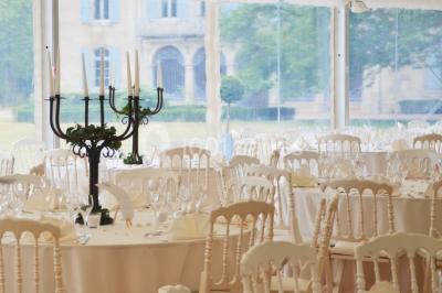 Des personnes en tenue blanche brandissent des cierges magiques lors d'un dîner en plein air devant un bâtiment éclairé.
