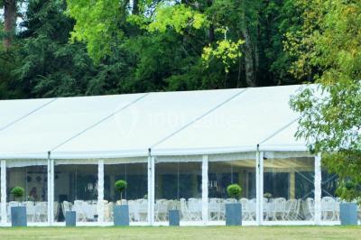 Des personnes en tenue blanche brandissent des cierges magiques lors d'un dîner en plein air devant un bâtiment éclairé.