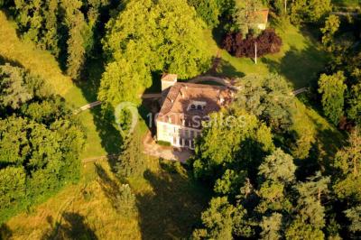 Des personnes en tenue blanche brandissent des cierges magiques lors d'un dîner en plein air devant un bâtiment éclairé.