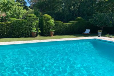 Miniature Location salle Triguères (Loiret) - Manoir du Grand Courtoiseau et ses Jardins Remarquables #25 Vaisselier rouge avec portes vitrées, contenant des verres, plats, bols et assiettes en céramique et en métal.
