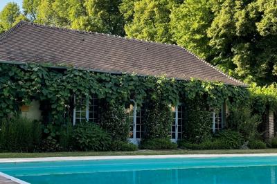 Miniature Location salle Triguères (Loiret) - Manoir du Grand Courtoiseau et ses Jardins Remarquables #27 Vaisselier rouge avec portes vitrées, contenant des verres, plats, bols et assiettes en céramique et en métal.