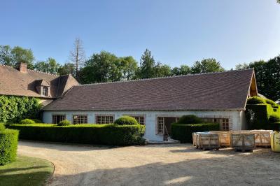 Miniature Location salle Triguères (Loiret) - Manoir du Grand Courtoiseau et ses Jardins Remarquables #29 Vaisselier rouge avec portes vitrées, contenant des verres, plats, bols et assiettes en céramique et en métal.