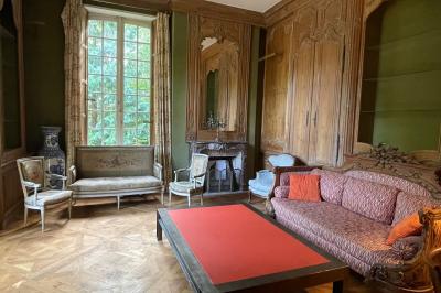 Miniature Location salle Triguères (Loiret) - Manoir du Grand Courtoiseau et ses Jardins Remarquables #33 Vaisselier rouge avec portes vitrées, contenant des verres, plats, bols et assiettes en céramique et en métal.