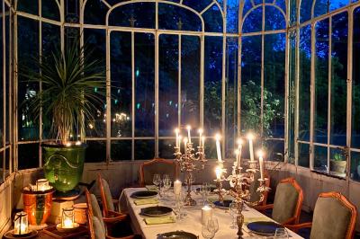 Miniature Location salle Triguères (Loiret) - Manoir du Grand Courtoiseau et ses Jardins Remarquables #36 Vaisselier rouge avec portes vitrées, contenant des verres, plats, bols et assiettes en céramique et en métal.