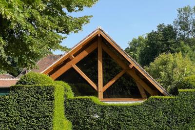 Miniature Location salle Triguères (Loiret) - Manoir du Grand Courtoiseau et ses Jardins Remarquables #31 Vaisselier rouge avec portes vitrées, contenant des verres, plats, bols et assiettes en céramique et en métal.