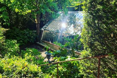 Miniature Location salle Triguères (Loiret) - Manoir du Grand Courtoiseau et ses Jardins Remarquables #18 Vaisselier rouge avec portes vitrées, contenant des verres, plats, bols et assiettes en céramique et en métal.