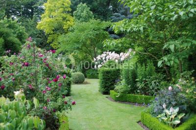 Miniature Location salle Triguères (Loiret) - Manoir du Grand Courtoiseau et ses Jardins Remarquables #8 Vaisselier rouge avec portes vitrées, contenant des verres, plats, bols et assiettes en céramique et en métal.
