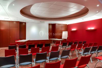 Façade moderne d'un bâtiment nommé ’Hôtel d'Entreprises Colisée’, entouré de verdure sous un ciel bleu.
