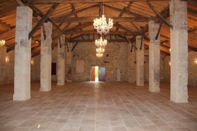 Château ancien avec deux tours rondes, vu depuis une grille en fer forgé ouverte, sous un ciel bleu.