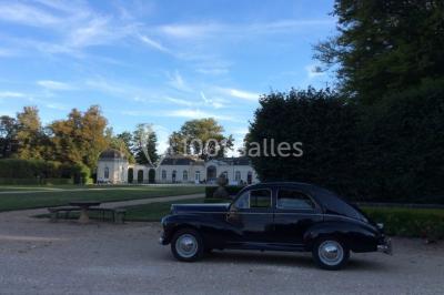 Miniature Location salle Ouzouer-sur-Trézée (Loiret) - Château de Pont-chevron #21 Voiture ancienne noire stationnée devant un bâtiment blanc entouré de jardins et d'arbres sous un ciel bleu.
