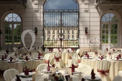 Miniature Location salle Ouzouer-sur-Trézée (Loiret) - Château de Pont-chevron #6 Voiture ancienne noire stationnée devant un bâtiment blanc entouré de jardins et d'arbres sous un ciel bleu.