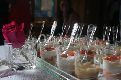 Piscine extérieure avec baigneurs, entourée de bâtiments en bois et de montagnes verdoyantes en arrière-plan.