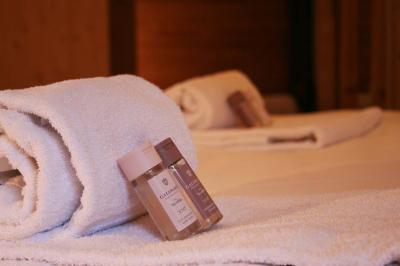 Piscine extérieure avec baigneurs, entourée de bâtiments en bois et de montagnes verdoyantes en arrière-plan.