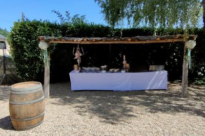 Voiture ancienne blanche décorée de fleurs, stationnée devant un bâtiment en pierre avec un toit en ardoise.