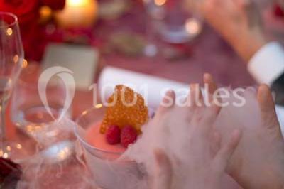 Vue d'un paysage boisé avec un bâtiment en pierre et un toit en ardoise partiellement visible au premier plan.