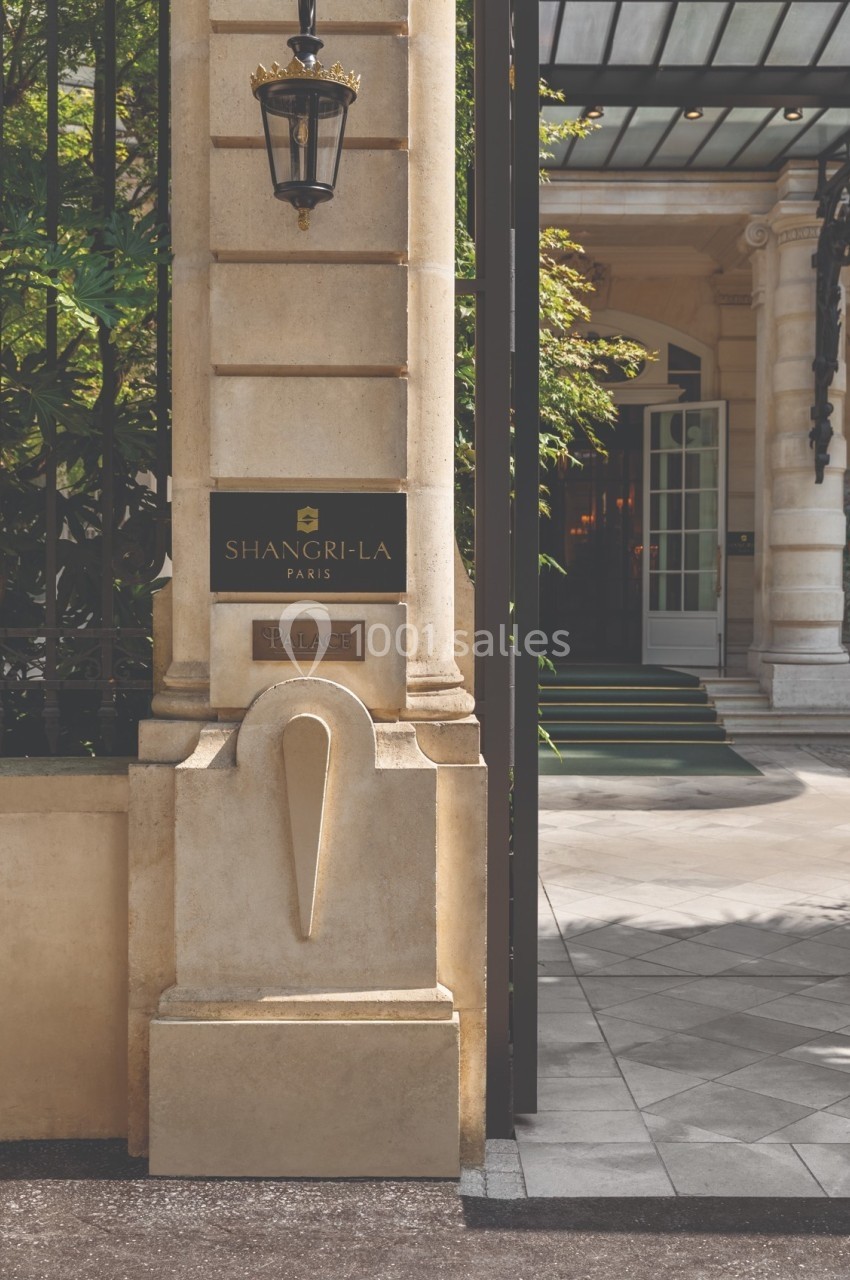 Entrée d'un hôtel de luxe avec une plaque indiquant ’Shangri-La Paris’, entourée d'une architecture élégante.