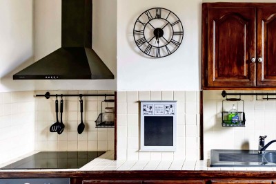 Trois bouteilles de vin posées sur un sol herbeux, entourées de fleurs blanches et jaunes.