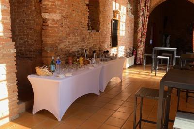 Un conférencier s'adresse à un public assis dans une salle avec un écran de projection et des murs en briques.