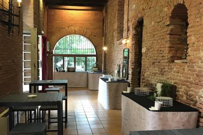 Un conférencier s'adresse à un public assis dans une salle avec un écran de projection et des murs en briques.