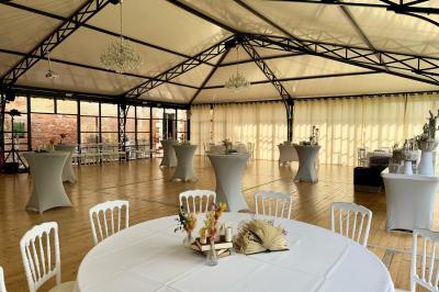 Un conférencier s'adresse à un public assis dans une salle avec un écran de projection et des murs en briques.