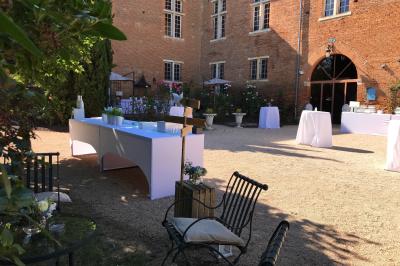 Un conférencier s'adresse à un public assis dans une salle avec un écran de projection et des murs en briques.
