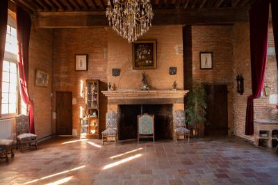 Un conférencier s'adresse à un public assis dans une salle avec un écran de projection et des murs en briques.