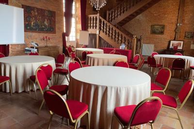 Un conférencier s'adresse à un public assis dans une salle avec un écran de projection et des murs en briques.