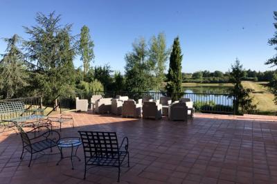 Un conférencier s'adresse à un public assis dans une salle avec un écran de projection et des murs en briques.