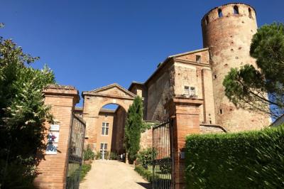 Un conférencier s'adresse à un public assis dans une salle avec un écran de projection et des murs en briques.