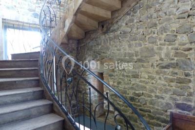 Vue aérienne d'une campagne avec des champs, des arbres, des maisons et des routes annotées pour indiquer des directions.