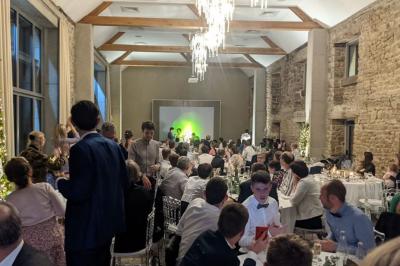 Vue aérienne d'une campagne avec des champs, des arbres, des maisons et des routes annotées pour indiquer des directions.