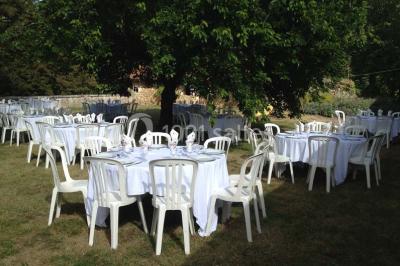Vue aérienne de plusieurs bus stationnés près d'un bâtiment ancien, entourés de groupes de personnes et de verdure.