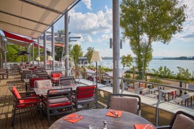 Chambre en bois avec un lit double, une fenêtre, un éclairage mural et une porte fermée.