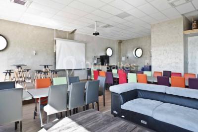 Chambre en bois avec un lit double, une fenêtre, un éclairage mural et une porte fermée.