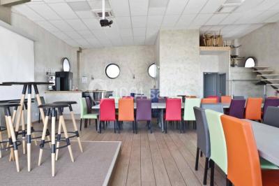 Chambre en bois avec un lit double, une fenêtre, un éclairage mural et une porte fermée.