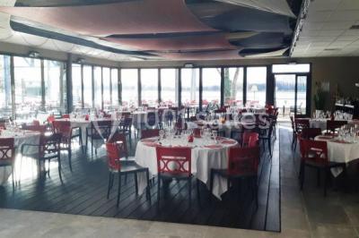 Foule dans une discothèque éclairée par des lumières bleues, avec une ambiance festive et un panneau lumineux au premier…