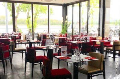 Foule dans une discothèque éclairée par des lumières bleues, avec une ambiance festive et un panneau lumineux au premier…