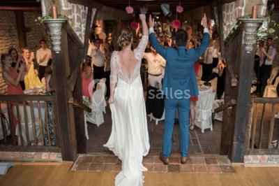 Dortoir sous combles avec murs en pierre, matelas au sol alignés et poutres apparentes.