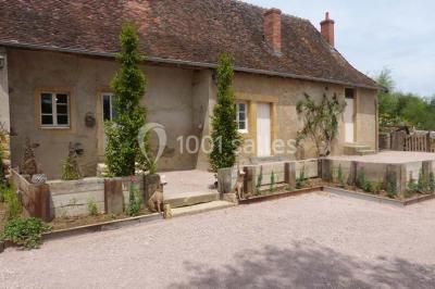 Dortoir sous combles avec murs en pierre, matelas au sol alignés et poutres apparentes.