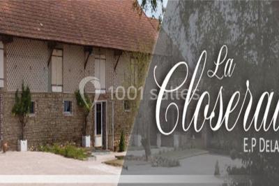 Dortoir sous combles avec murs en pierre, matelas au sol alignés et poutres apparentes.