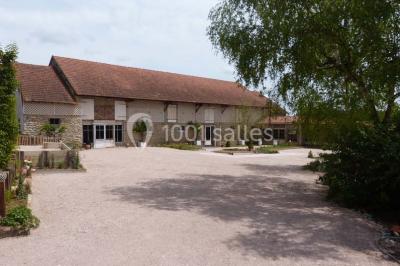 Dortoir sous combles avec murs en pierre, matelas au sol alignés et poutres apparentes.