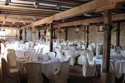 Dortoir sous combles avec murs en pierre, matelas au sol alignés et poutres apparentes.