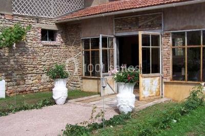 Dortoir sous combles avec murs en pierre, matelas au sol alignés et poutres apparentes.