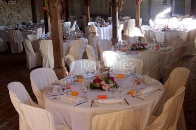 Dortoir sous combles avec murs en pierre, matelas au sol alignés et poutres apparentes.