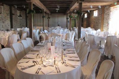 Dortoir sous combles avec murs en pierre, matelas au sol alignés et poutres apparentes.