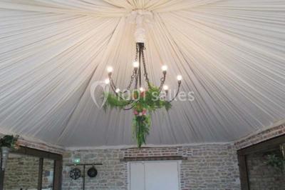 Dortoir sous combles avec murs en pierre, matelas au sol alignés et poutres apparentes.