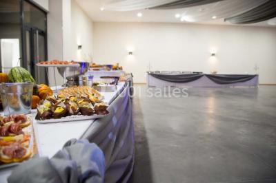 Parking vide avec marquages au sol, situé devant un bâtiment en bois entouré d'arbres et de montagnes.