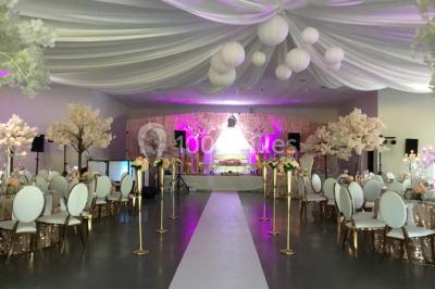 Parking vide avec marquages au sol, situé devant un bâtiment en bois entouré d'arbres et de montagnes.