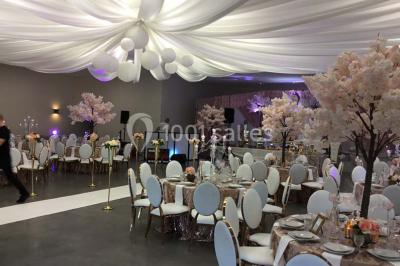 Parking vide avec marquages au sol, situé devant un bâtiment en bois entouré d'arbres et de montagnes.